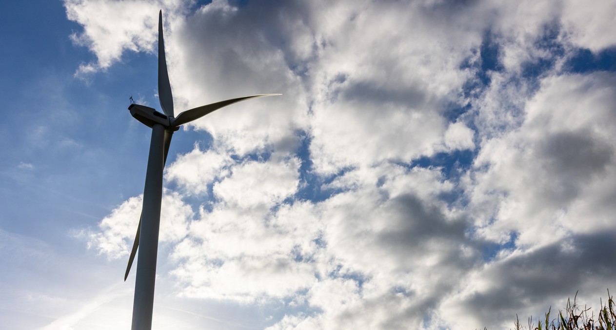 Wind turbine against cloudy sky