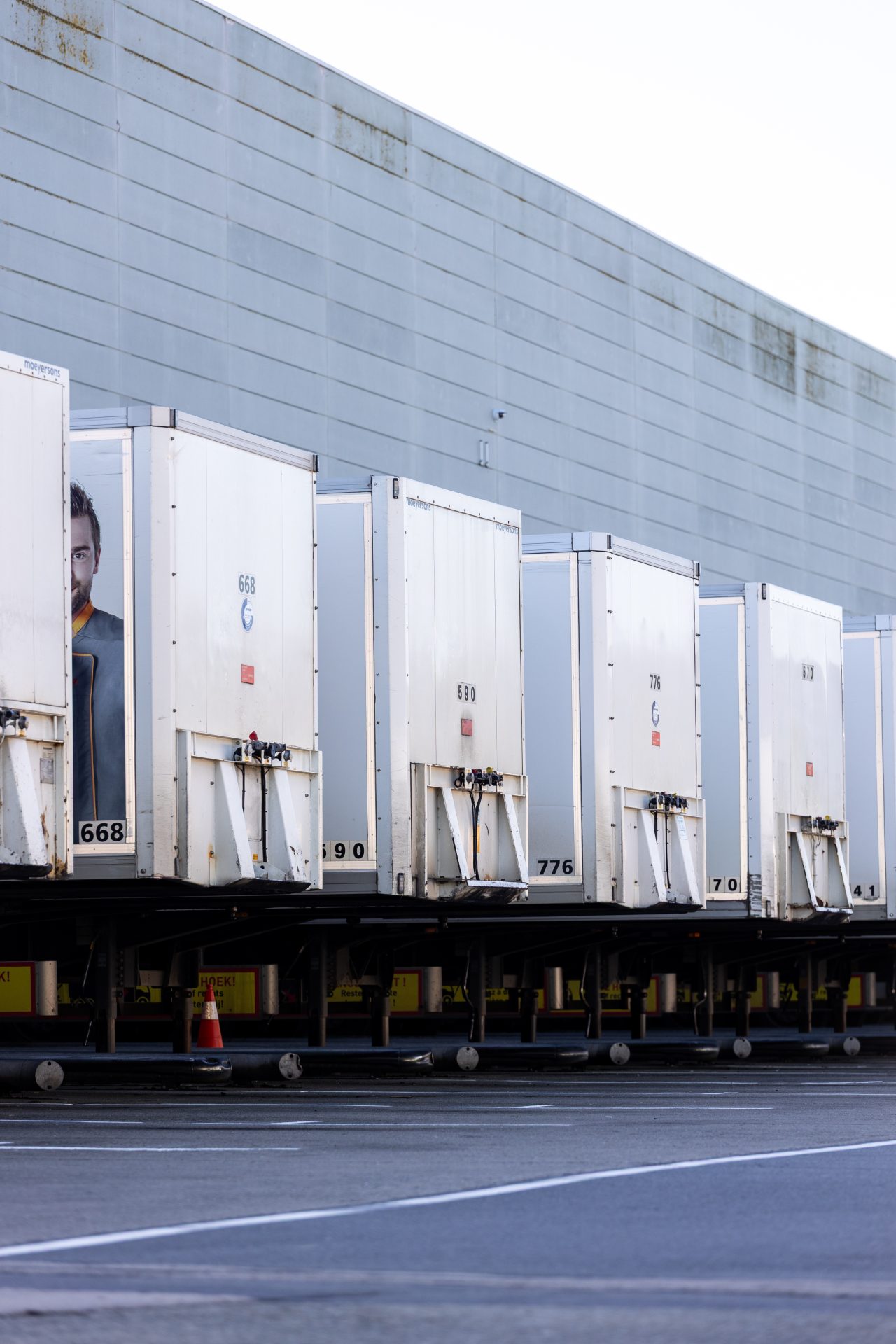 Row of white cargo trailers parked.